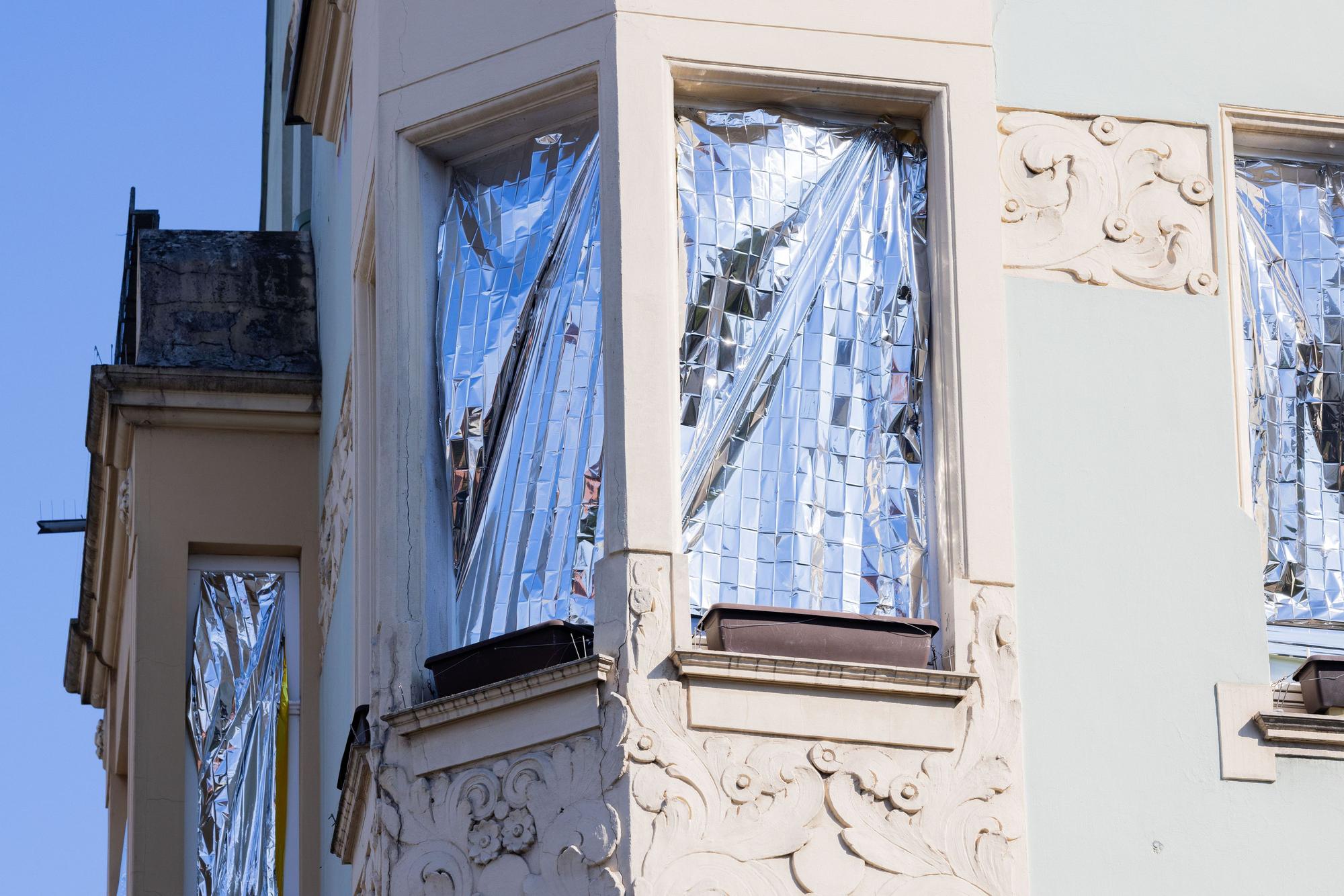 Menschen schützen ihre Wohnungen mit Rettungsdecken, die mit Aluminium beschichtet sind, vor der Hitze und der Sonne.