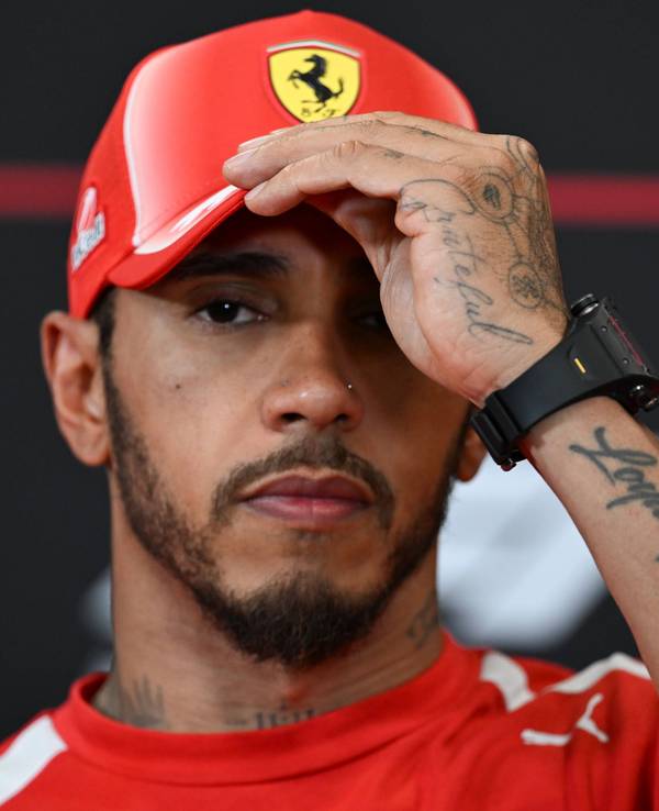 Lewis Hamilton fasst sich an die Ferrari-Kappe.