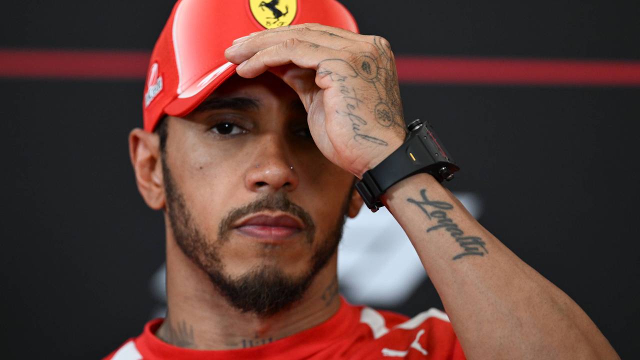 Lewis Hamilton fasst sich an die Ferrari-Kappe.
