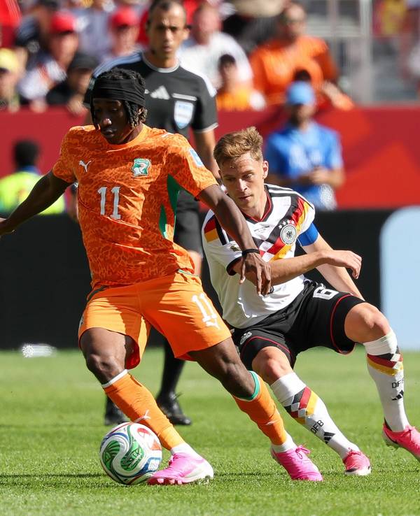 Yan Diomande schirmt den Ball vor Joshua Kimmich ab.