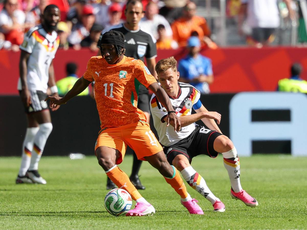 Yan Diomande schirmt den Ball vor Joshua Kimmich ab.