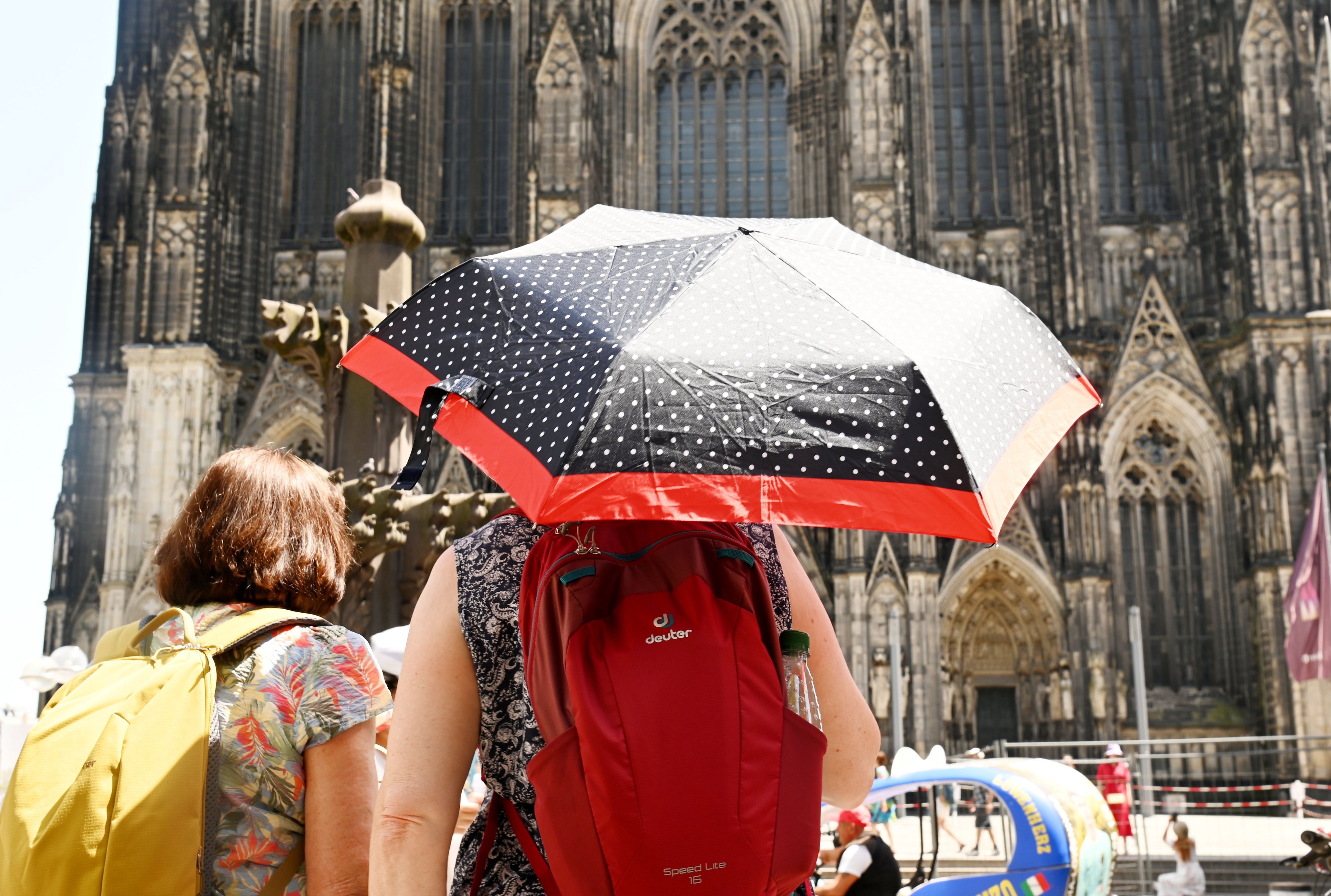 Für Köln und ganz NRW werden erneut Temperaturen jenseits der 30-Grad-Marke vorhergesagt. Schon im Juni schützten sich Menschen mit Schirmen gegen die Hitze.