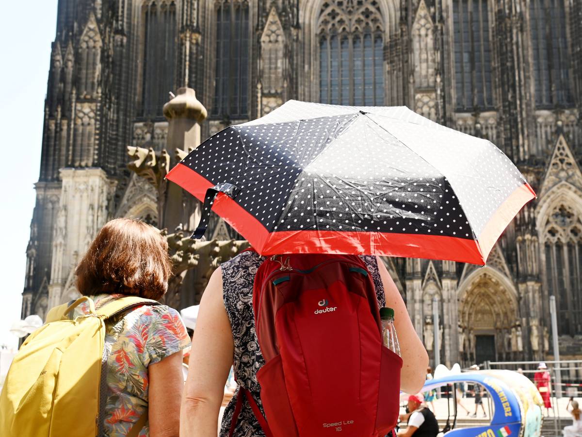 Für Köln und ganz NRW werden erneut Temperaturen jenseits der 30-Grad-Marke vorhergesagt. Schon im Juni schützten sich Menschen mit Schirmen gegen die Hitze.