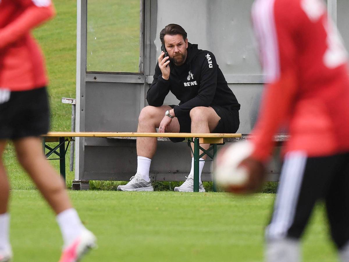 Thomas Kessler telefoniert während des Trainings beim 1. FC Köln.