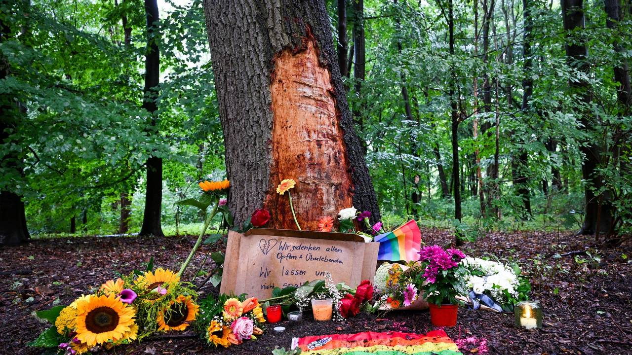 Blumen, Kerzen und die Botschaft „Wir gedenken aller Opfer und Überlebenden“ sind an einem Baum mit beschädigter Rinde zu sehen, wo ein Fahrzeug am Rande des Christopher Street Day in eine Menschenmenge gefahren war.