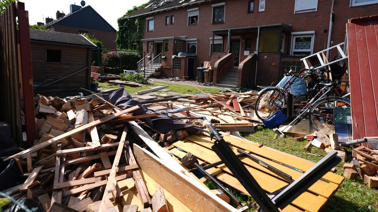 Provisorische Planen bedecken das durch ein Unwetter abgedeckte Dach eines Reihenhauses. Im Vordergrund liegen Teile einer zerstörten Gartenlaube und Dachziegel. Ein mutmaßlicher Tornado hat in und um Glückstadt in Schleswig-Holstein eine Schneise der Verwüstung geschlagen und nach ersten Schätzungen Schäden in sechs- bis siebenstelliger Höhe verursacht.