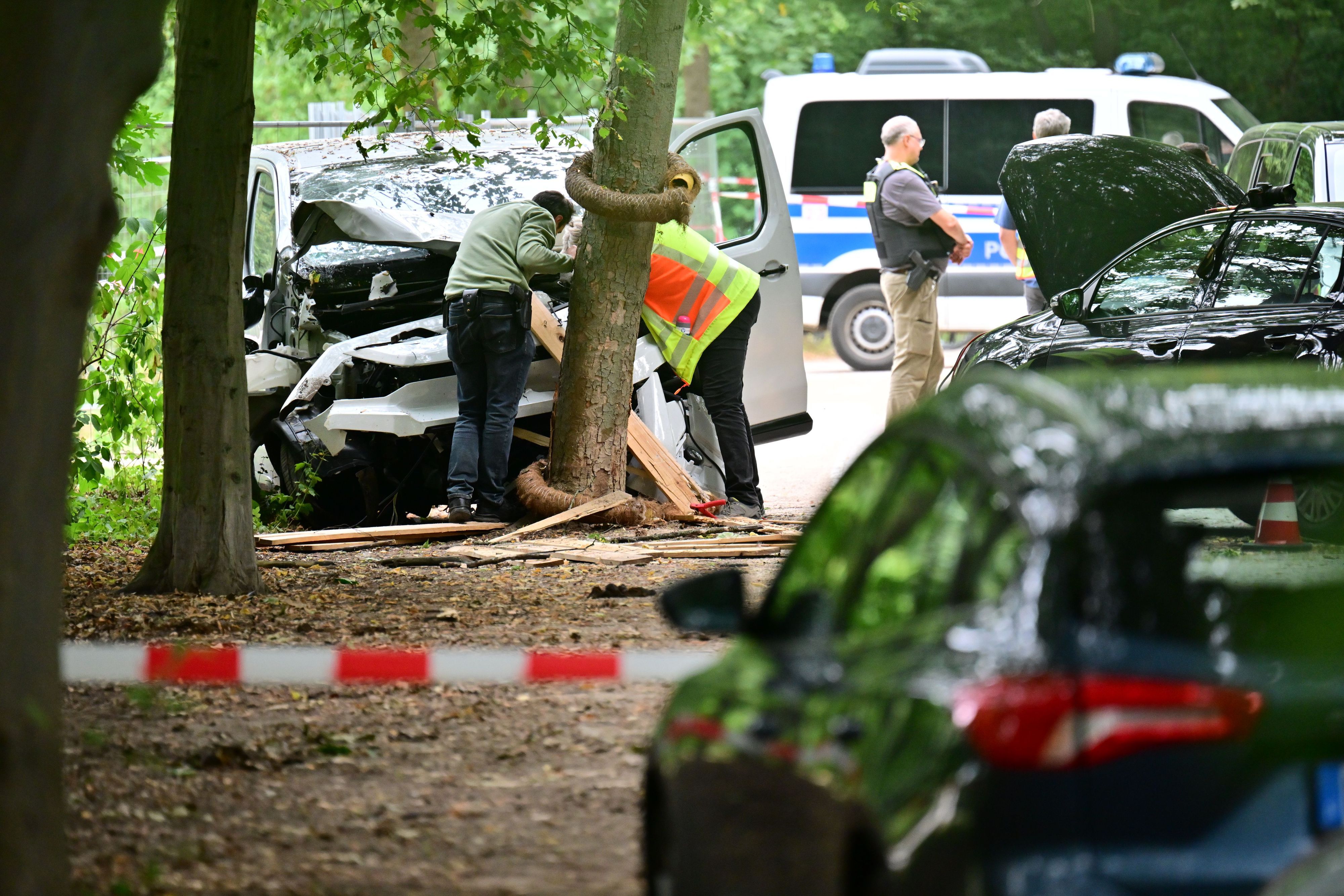 Ein Mitarbeiter der Unfallforschung betrachtet ein Fahrzeug, das in einen Baum im Bereich des Tiergartens gefahren ist.