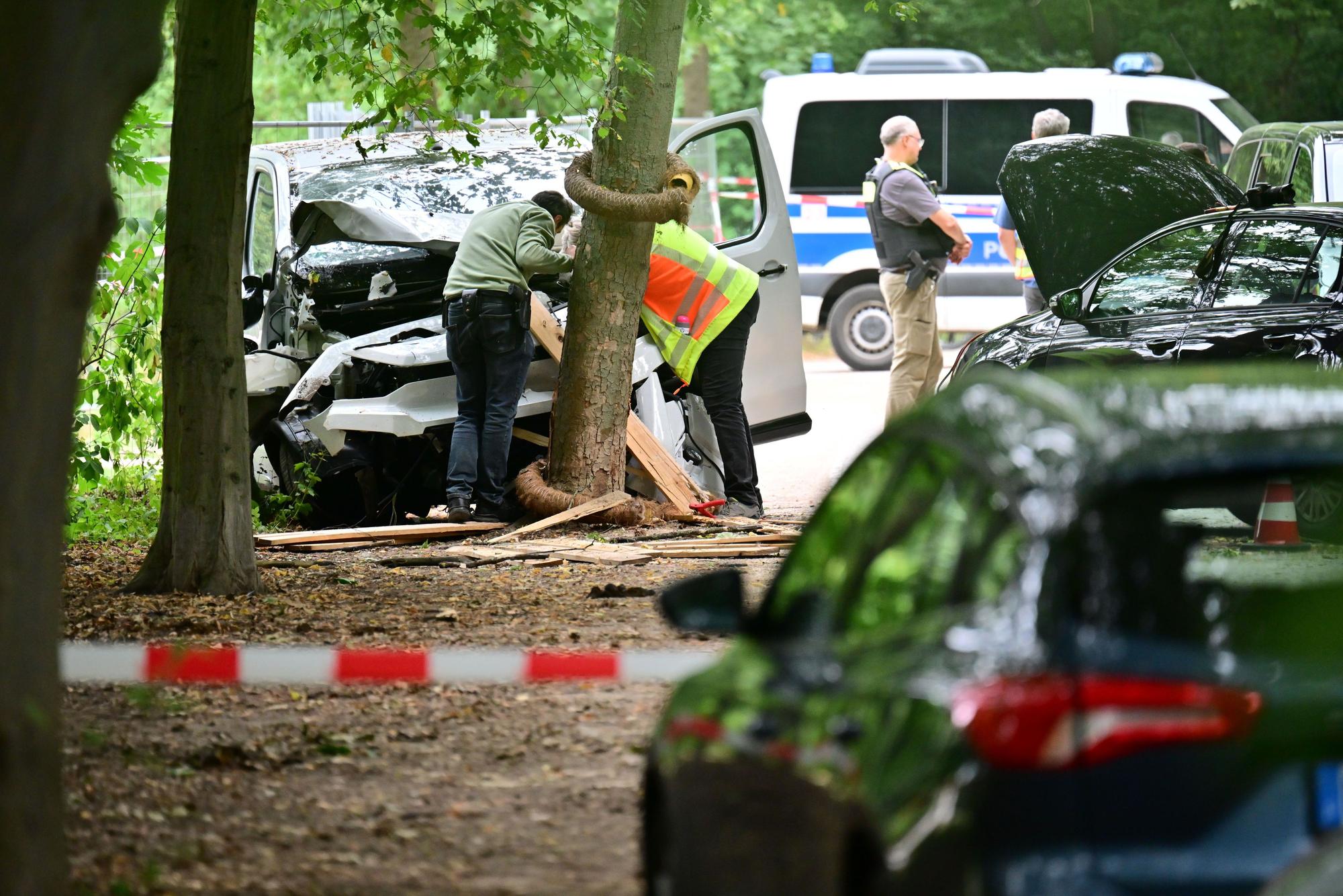 Ein Mitarbeiter der Unfallforschung betrachtet ein Fahrzeug, das in einen Baum im Bereich des Tiergartens gefahren ist.
