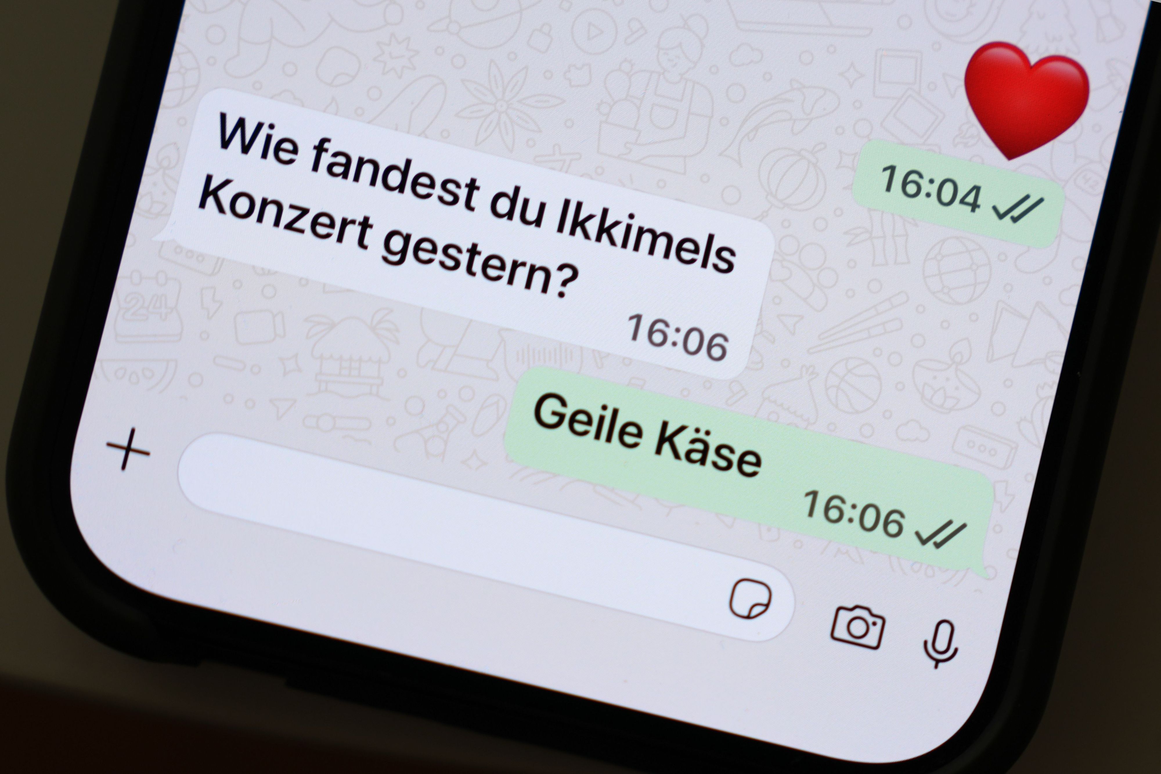 Die Wörter „Geile Käse“ sind auf dem Display eines Smartphones in einem Chatverlauf zu lesen.