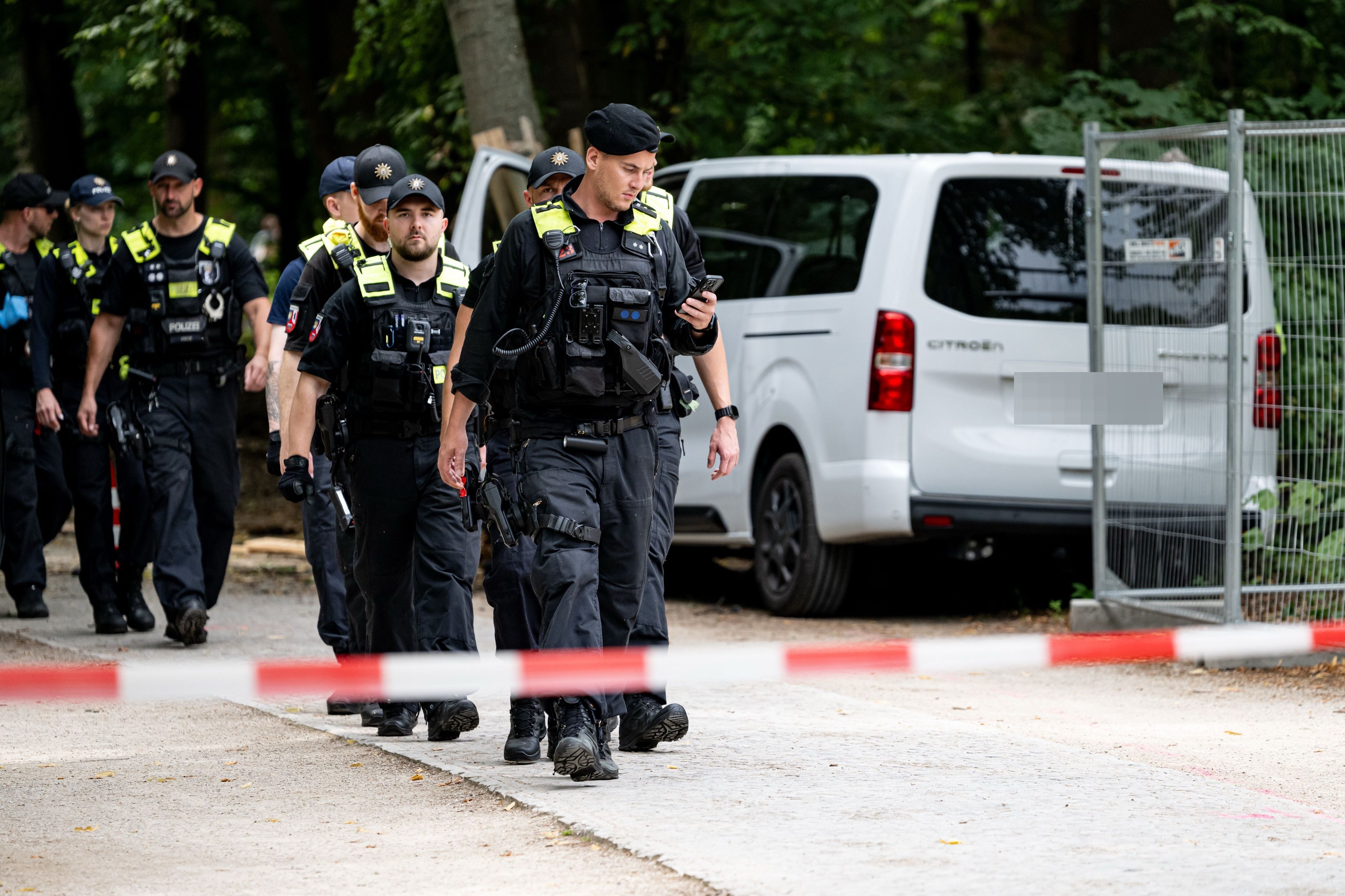 Polizisten laufen an dem Wagen vorbei, mit dem ein Mann am Rande des CSD in eine Menschenmenge fuhr.