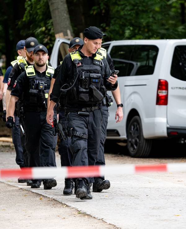 Polizisten laufen an dem Wagen vorbei, mit dem ein Mann am Rande des CSD in eine Menschenmenge fuhr.
