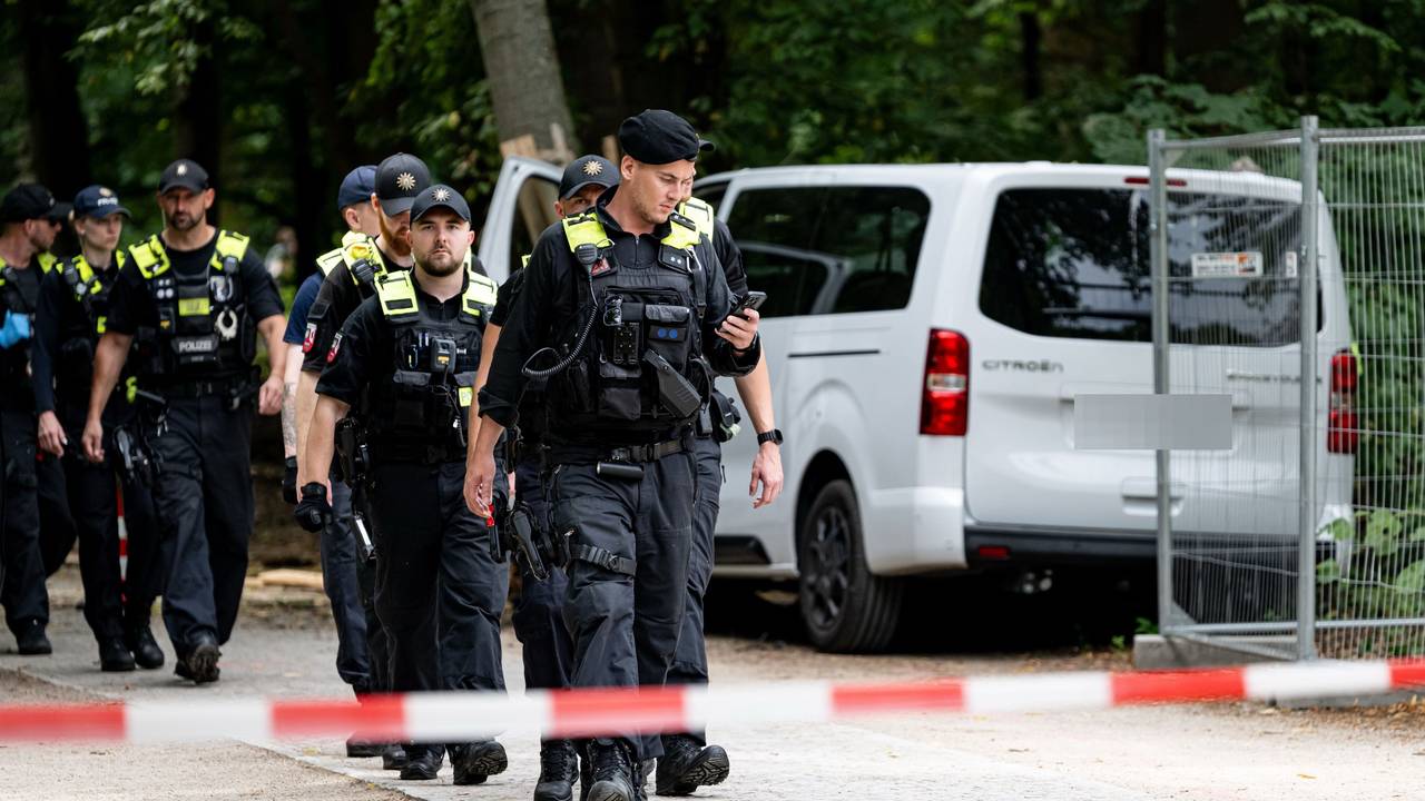 Polizisten laufen an dem Wagen vorbei, mit dem ein Mann am Rande des CSD in eine Menschenmenge fuhr.