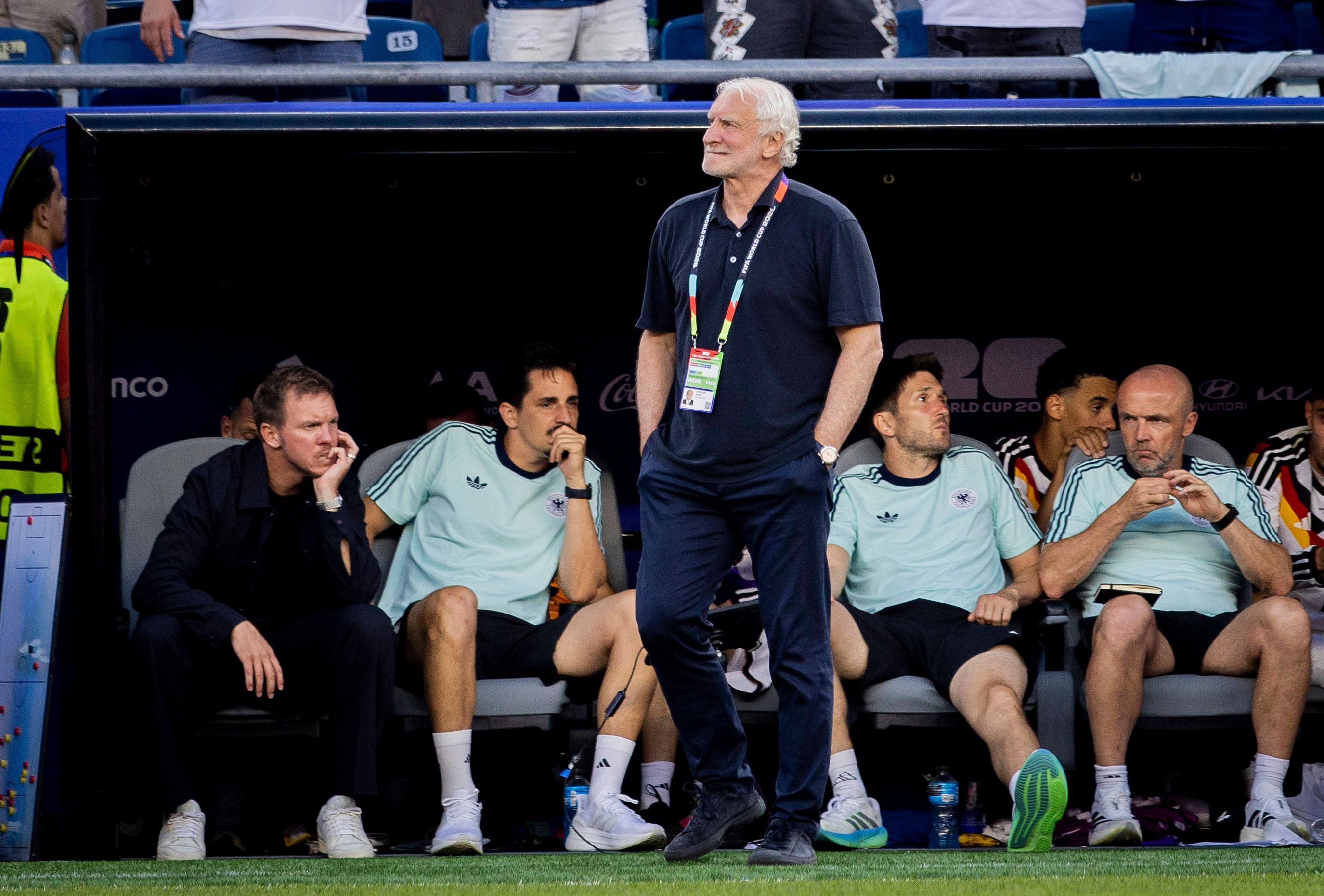 Rudi Völler geht vor der Trainerbank, auf der Julian Nagelsmann enttäuscht sitzt.