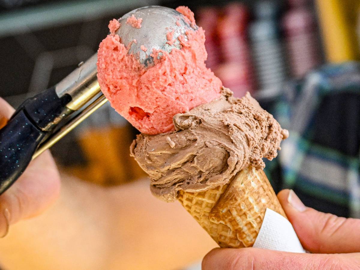 In einer Eisdiele werden zwei Eiskugeln in eine Waffel gefüllt.