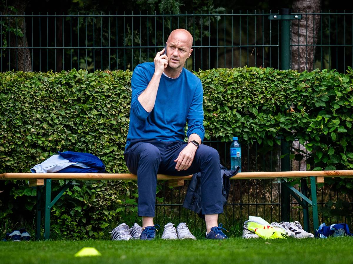 Am Rande des Trainings von Ajax Amsterdam telefoniert Jordy Cruyff auf einer Bierbank sitzend.