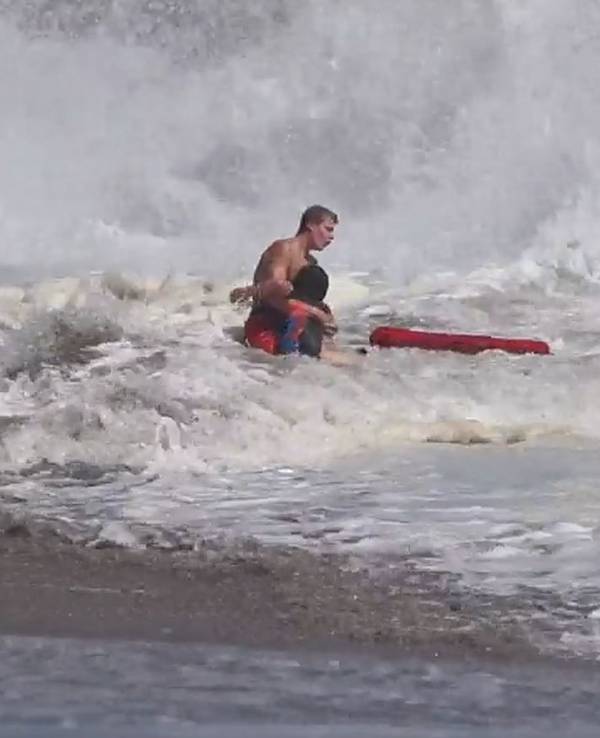 Rettungsschwimmer rettet Kind an einem kalifornischen Strand.