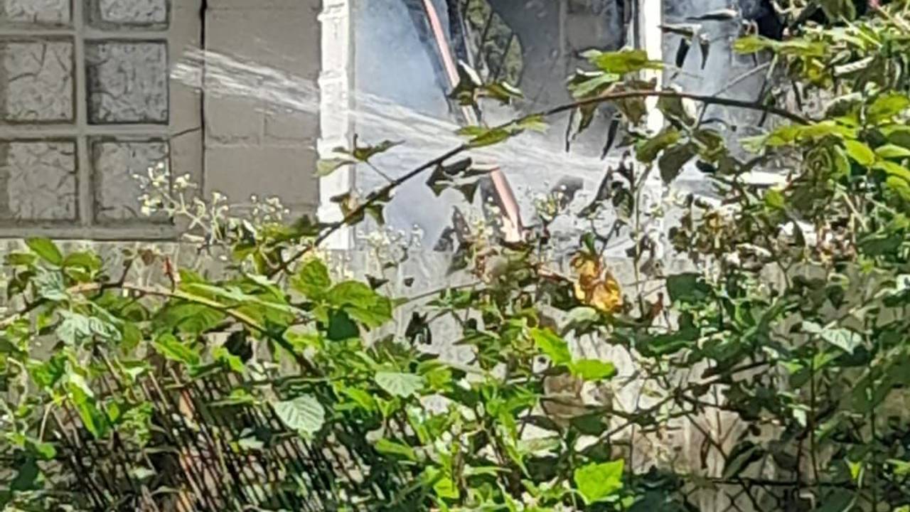 Das Dach einer Gartenlaube ist rußgeschwärzt, aus dem Inneren qualmt es.