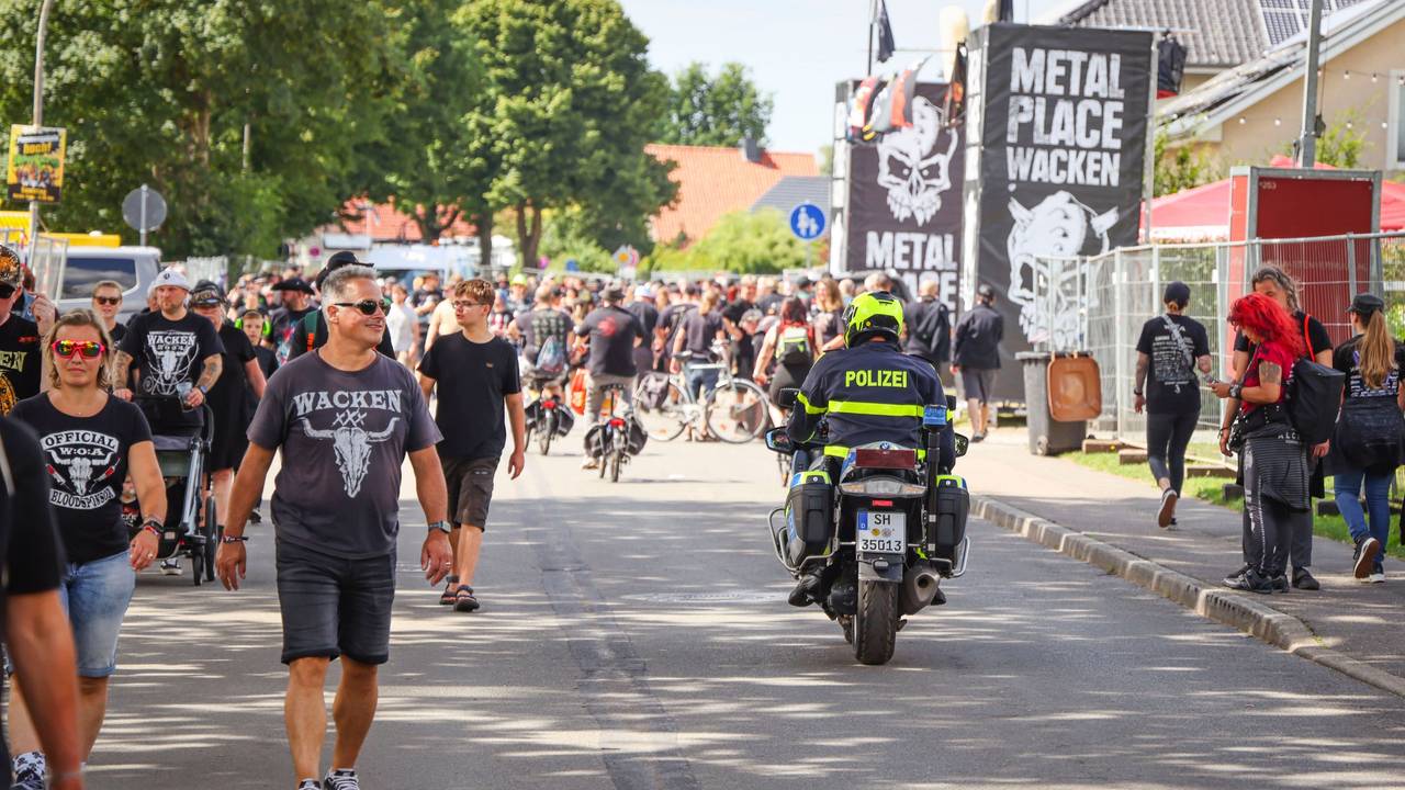 Ein Polizeibeamter fährt während des Wacken Open Air (W:O:A) mit einem Motorrad durch die Ortsmitte