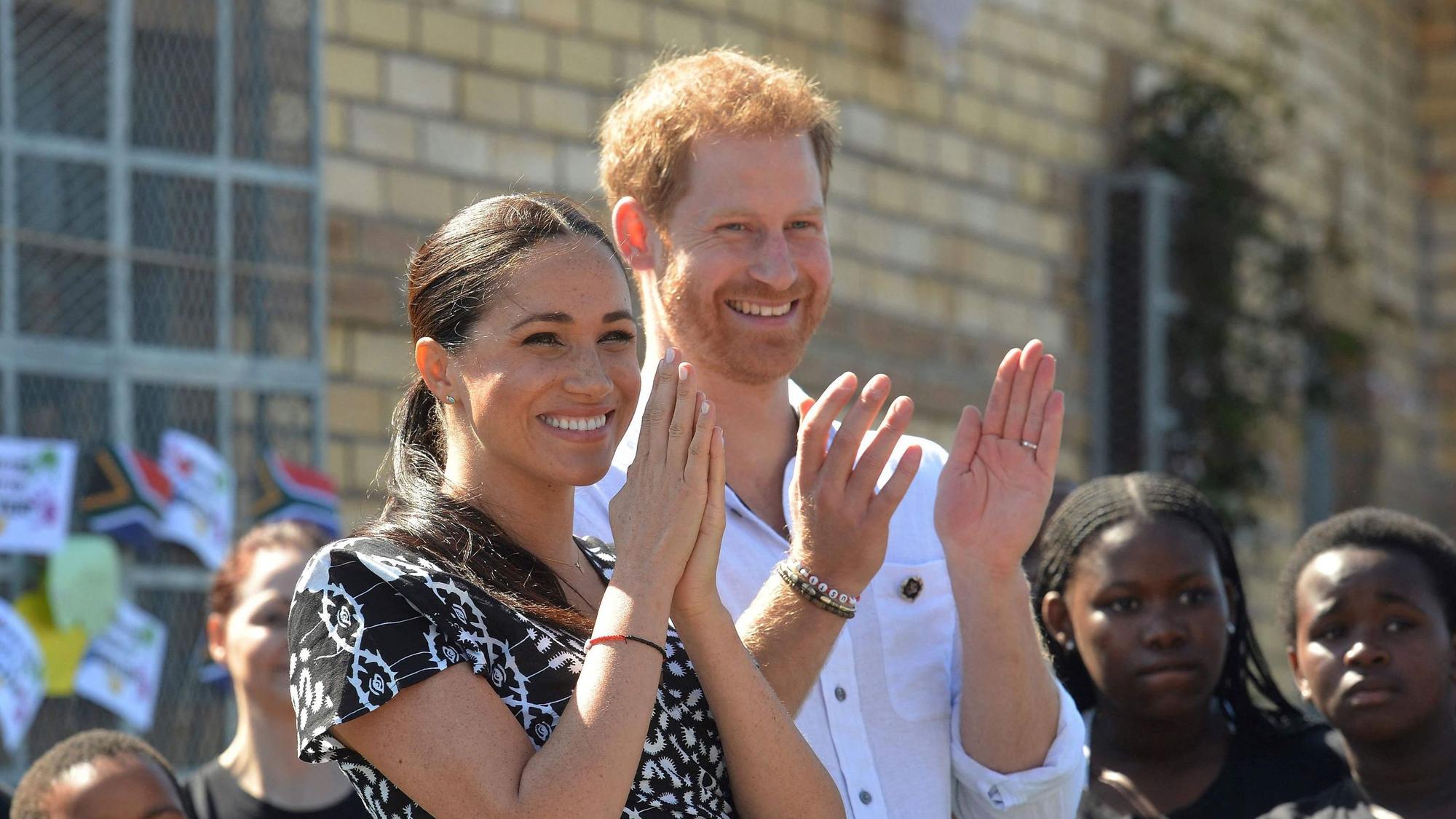 Prinz Harry und Herzogin Meghan klatschen.