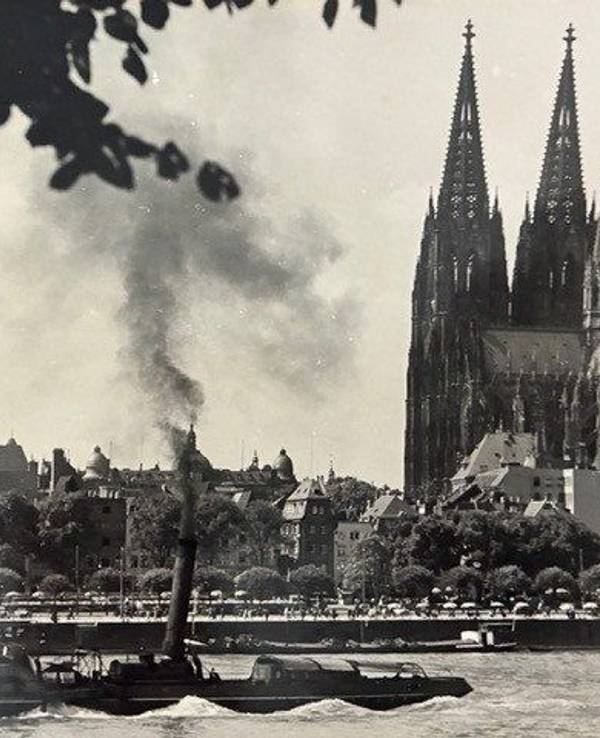 Ein Dampfschiff fährt an Köln vorbei.