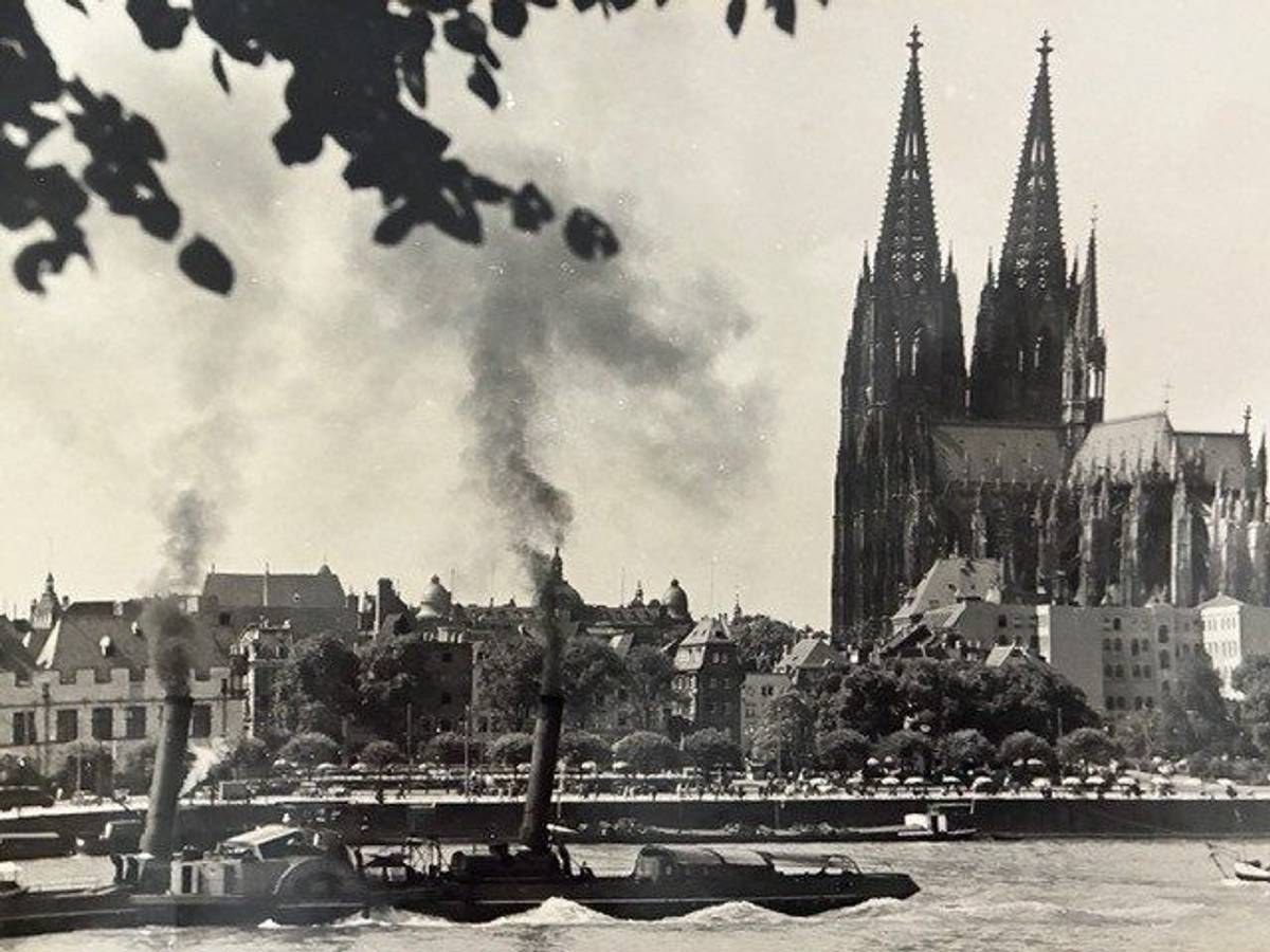 Ein Dampfschiff fährt an Köln vorbei.