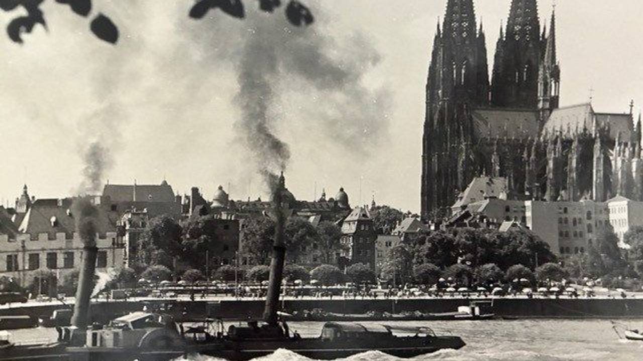 Ein Dampfschiff fährt an Köln vorbei.
