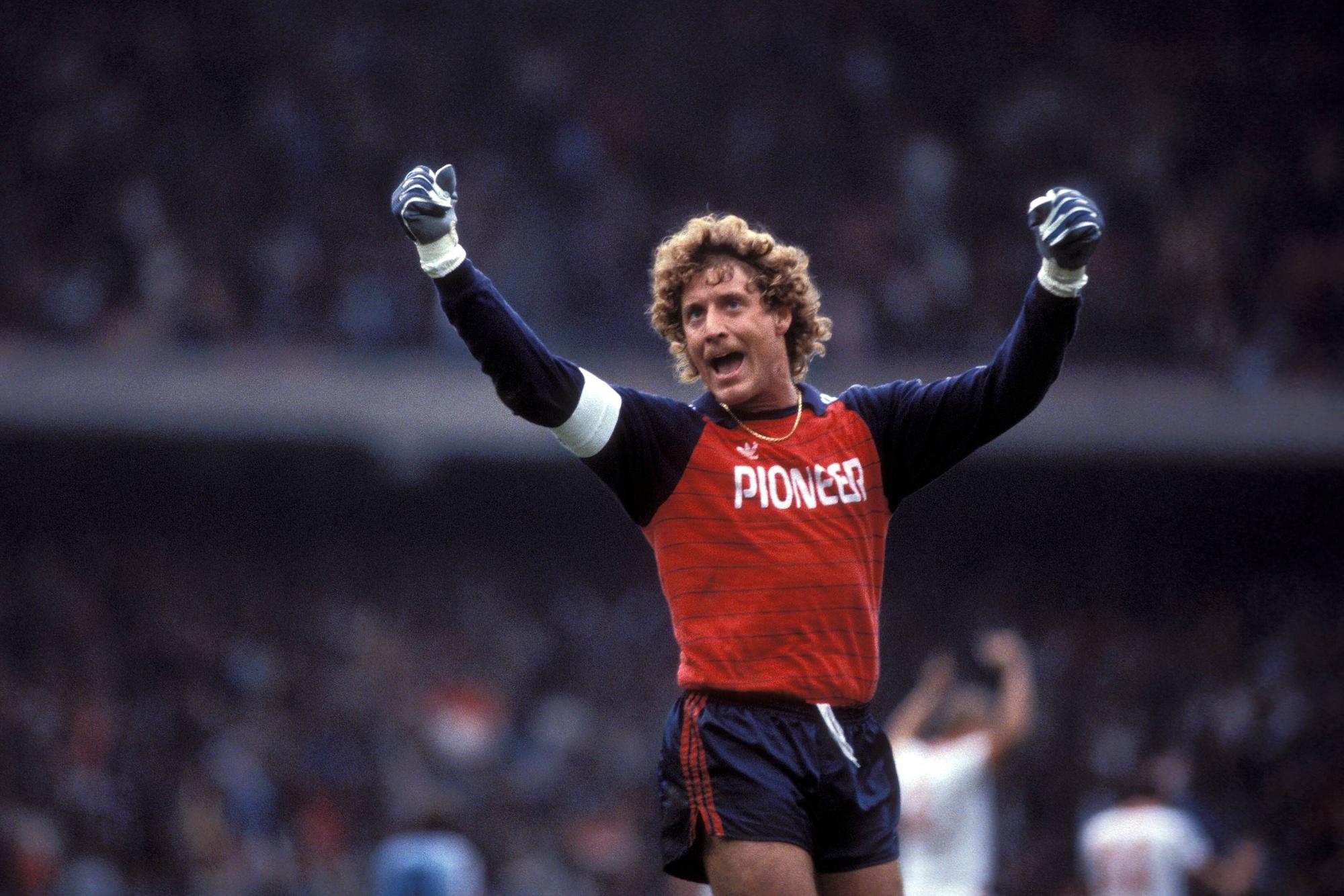 Toni Schumacher jubelt im blau-roten Trikot.