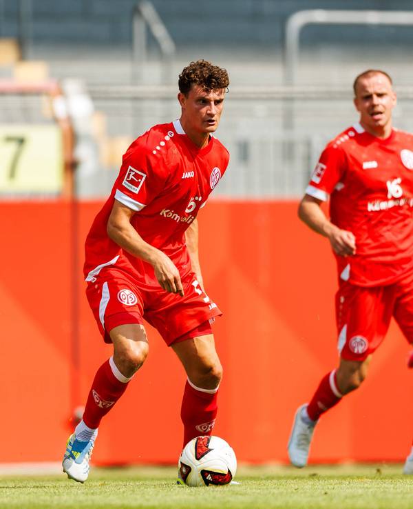 Eric Martel (M.) mit Ball in Aktion.