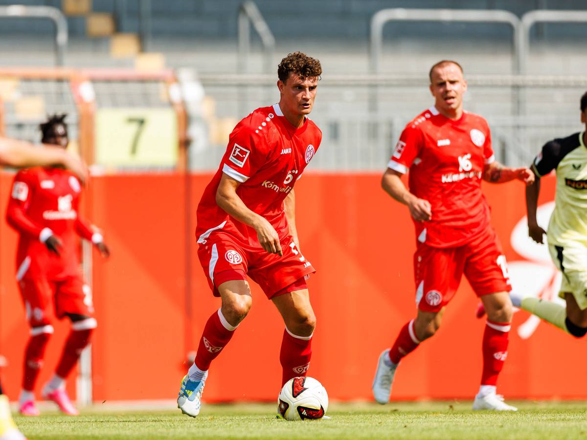 Eric Martel (M.) mit Ball in Aktion.