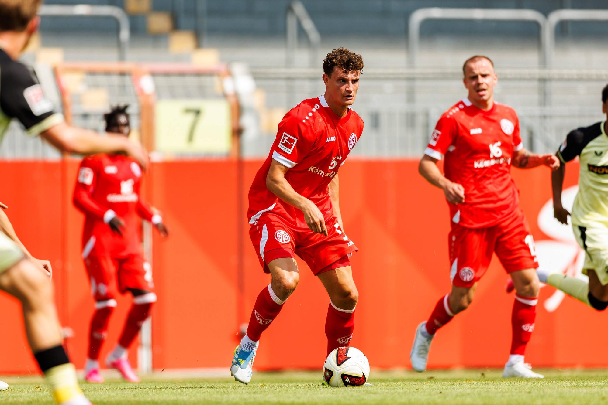 Eric Martel (M.) mit Ball in Aktion.