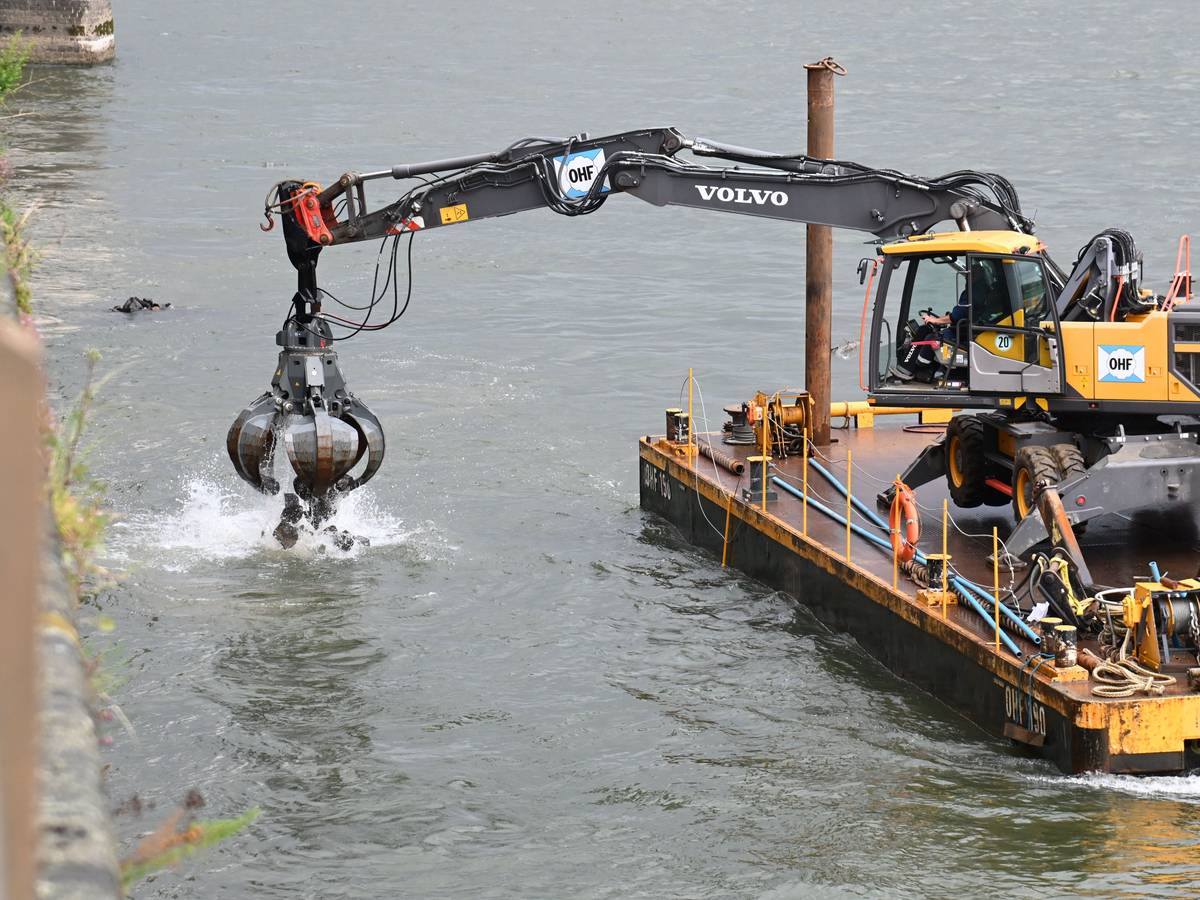 Am Rheinufer vor dem Rheinauhafen liegen Schiffe einer Wasserbaufirma vor der Kaimauer vor Anker und führen Arbeiten durch.