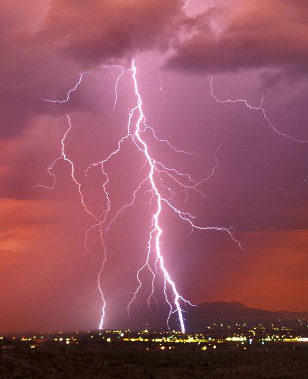Ein riesiger Blitz zuckt vom Himmel auf eine Stadt hernieder