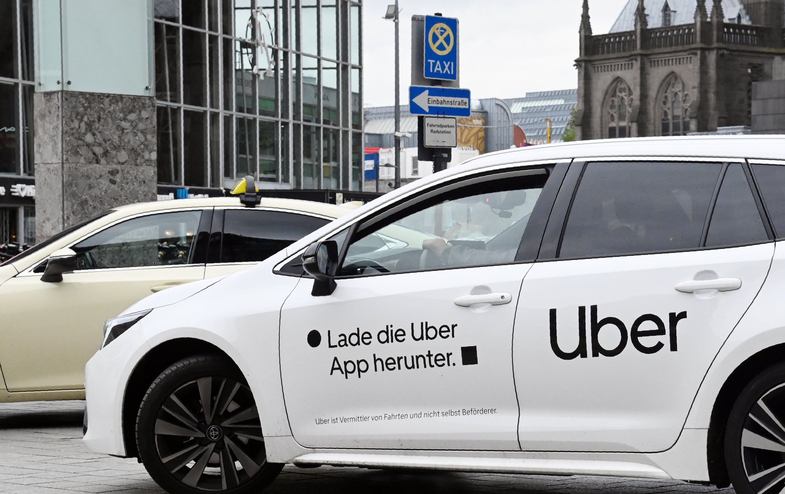 Am Taxistand vor dem Kölner Hauptbahnhof steht ein Fahrzeug von Uber.