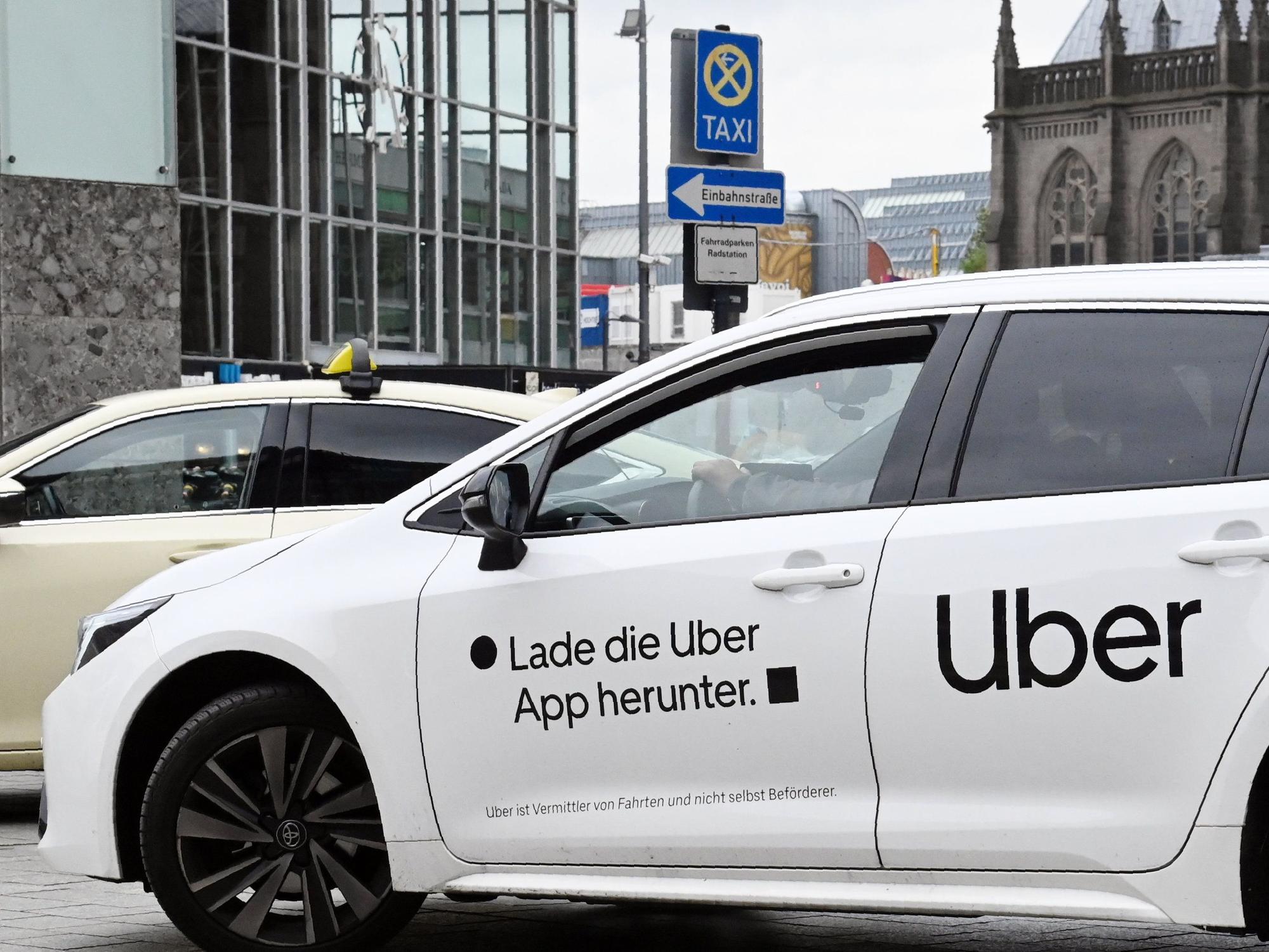 Am Taxistand vor dem Kölner Hauptbahnhof steht ein Fahrzeug von Uber.