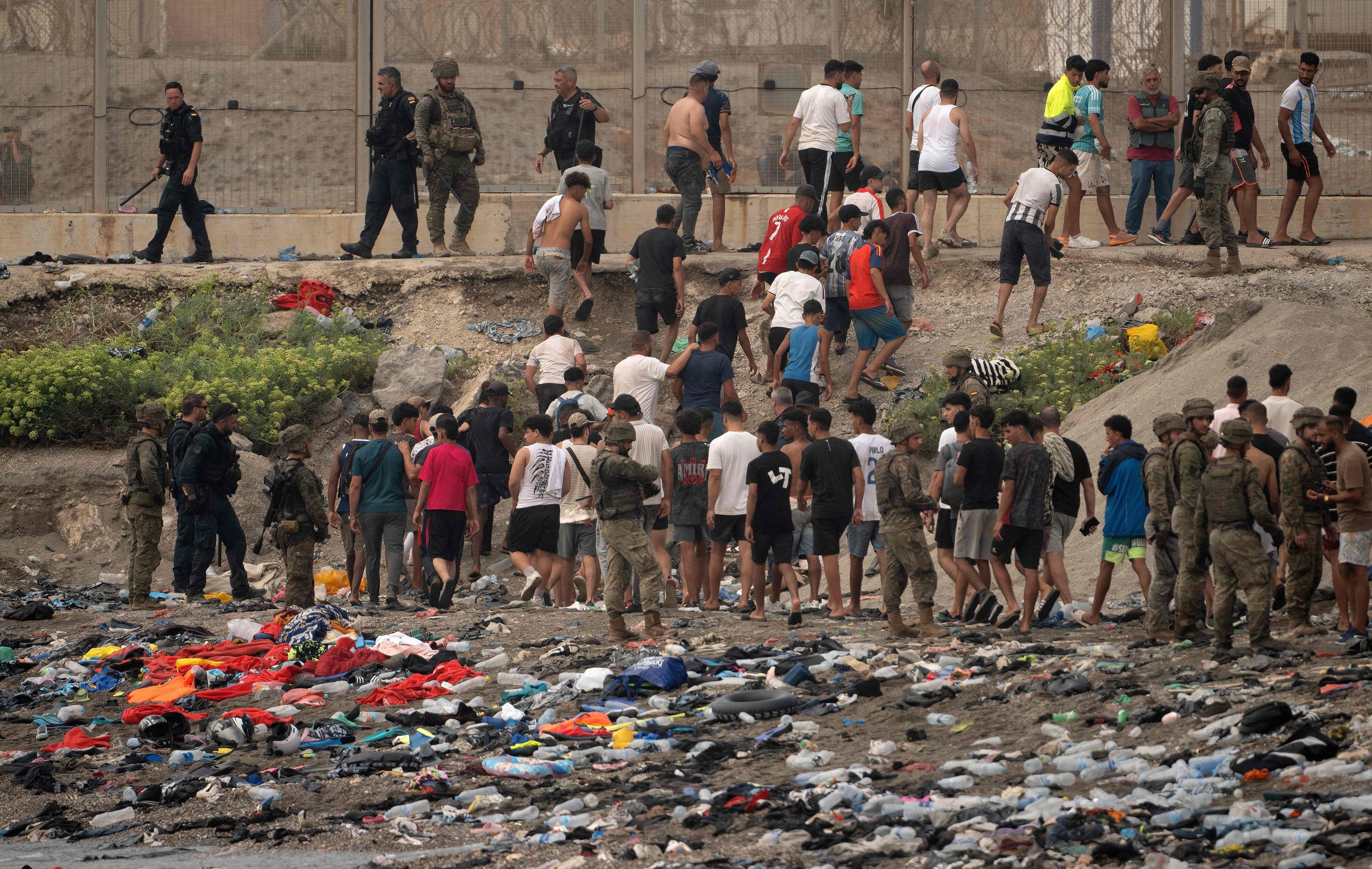 Spanische Soldaten überwachen Migranten, die nach Marokko zurückkehren, nachdem sie am 31. Juli 2026 die Grenze überquert hatten, um in die spanische Enklave Ceuta in Nordafrika einzureisen.