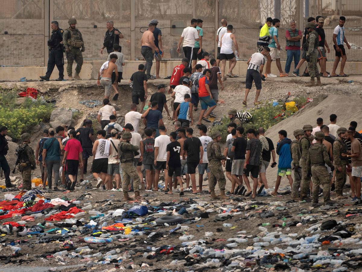 Spanische Soldaten überwachen Migranten, die nach Marokko zurückkehren, nachdem sie am 31. Juli 2026 die Grenze überquert hatten, um in die spanische Enklave Ceuta in Nordafrika einzureisen.
