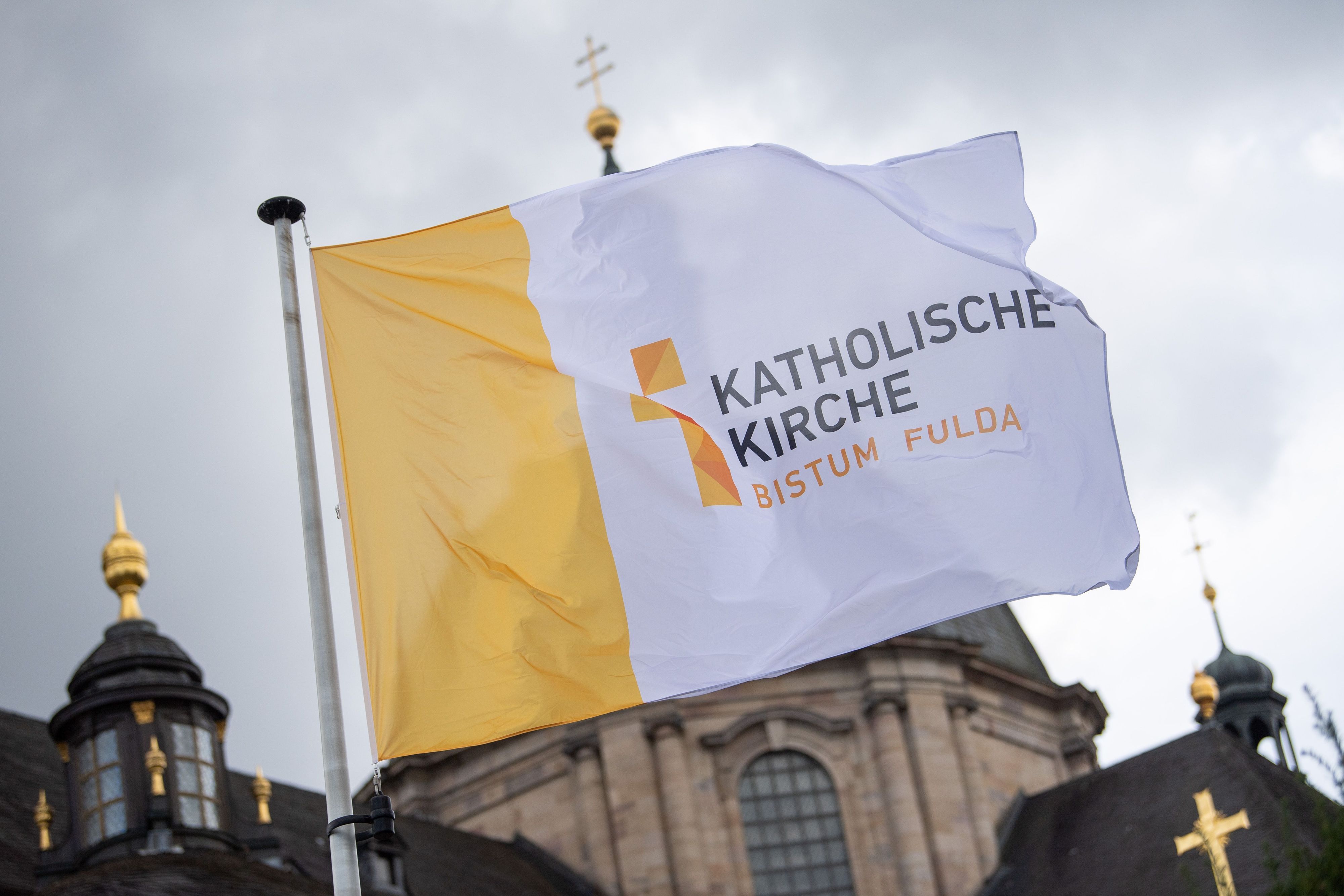 ARCHIV - 26.09.2022, Hessen, Fulda: Eine Fahne mit der Aufschrift „Katholische Kirche Bistum Fulda“ weht vor der Herbstvollversammlung der Deutschen Bischofskonferenz vor dem Dom St. Salvator zu Fulda. (zu dpa: «Bistum Fulda distanziert sich von homophoben Aussagen») Foto: Sebastian Gollnow/dpa +++ dpa-Bildfunk +++