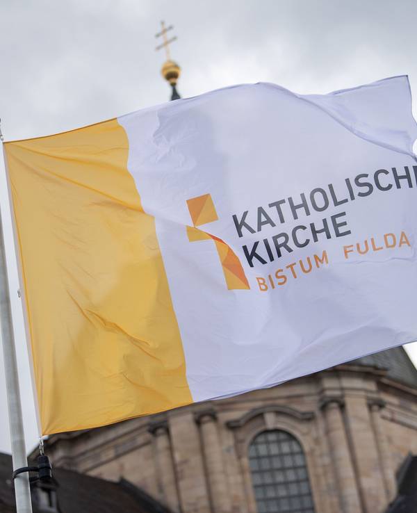ARCHIV - 26.09.2022, Hessen, Fulda: Eine Fahne mit der Aufschrift „Katholische Kirche Bistum Fulda“ weht vor der Herbstvollversammlung der Deutschen Bischofskonferenz vor dem Dom St. Salvator zu Fulda. (zu dpa: «Bistum Fulda distanziert sich von homophoben Aussagen») Foto: Sebastian Gollnow/dpa +++ dpa-Bildfunk +++