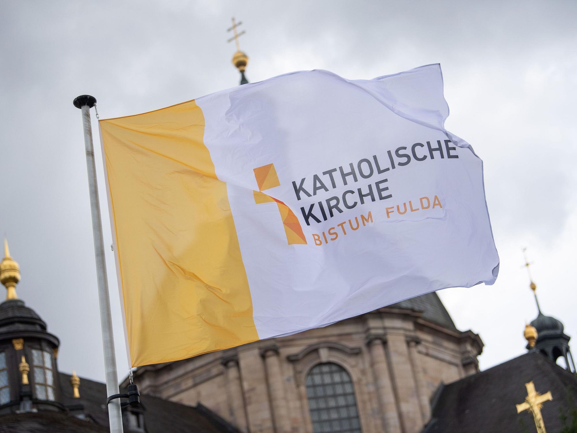ARCHIV - 26.09.2022, Hessen, Fulda: Eine Fahne mit der Aufschrift „Katholische Kirche Bistum Fulda“ weht vor der Herbstvollversammlung der Deutschen Bischofskonferenz vor dem Dom St. Salvator zu Fulda. (zu dpa: «Bistum Fulda distanziert sich von homophoben Aussagen») Foto: Sebastian Gollnow/dpa +++ dpa-Bildfunk +++