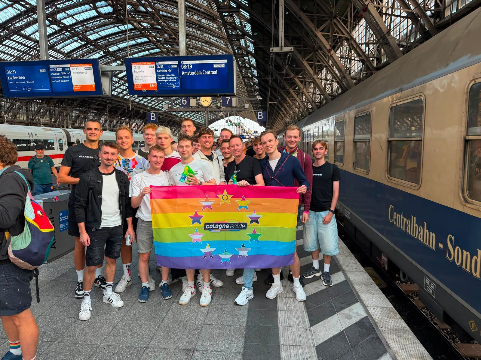 Das Team von Cologne Pride e.V. (Mitveranstalter der Fahrt) am Gleis des Kölner Hauptbahnhofs vor der Abfahrt.