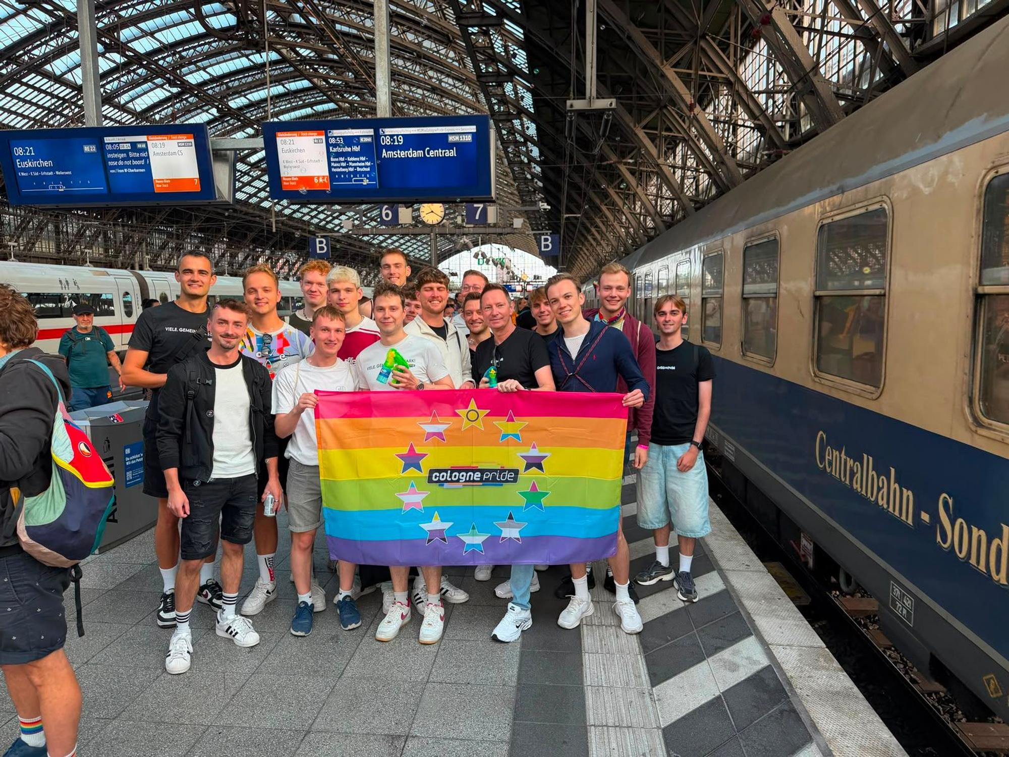 Das Team von Cologne Pride e.V. (Mitveranstalter der Fahrt) am Gleis des Kölner Hauptbahnhofs vor der Abfahrt.