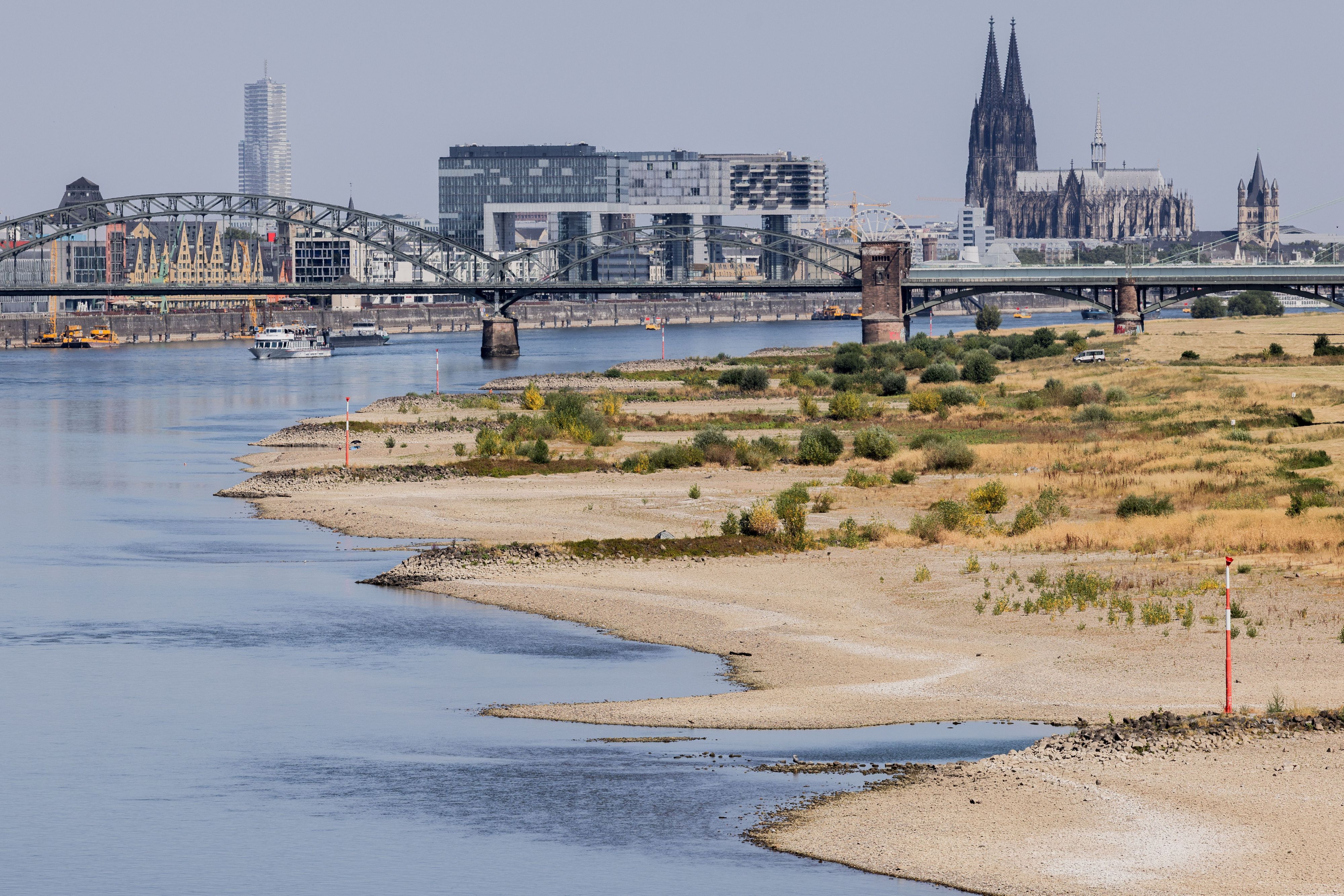 Binnenschiffe fahren bei Niedrigwasser vor der Kulisse des Kölner Doms über den Rhein.