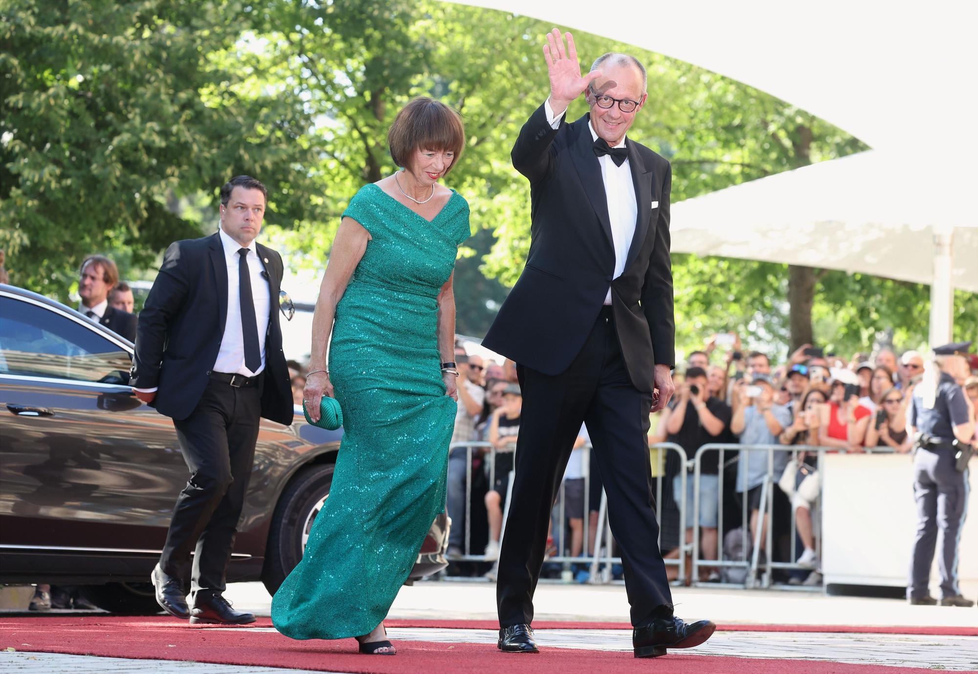 Schon ein kleiner Vorgeschmack auf den Urlaub? Bundeskanzler Friedrich Merz (r., CDU) und seine Frau Charlotte Merz kommen am 25. Juli zur Eröffnung der Richard-Wagner-Festspiele zum Festspielhaus Bayreuth.