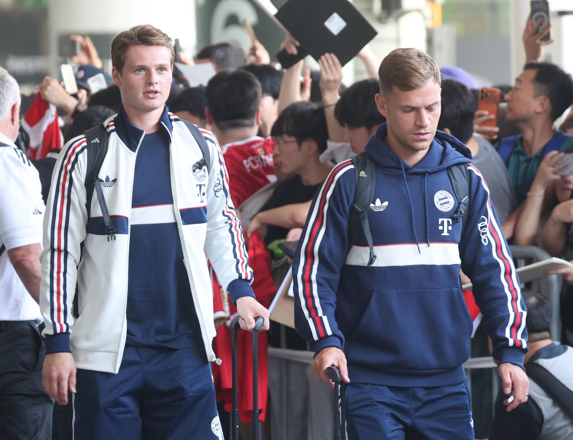 Joshua Kimmich (r.) und Jonas Urbig gehen am Flughafen in Jeju an den südkoreanischen Fans vorbei.