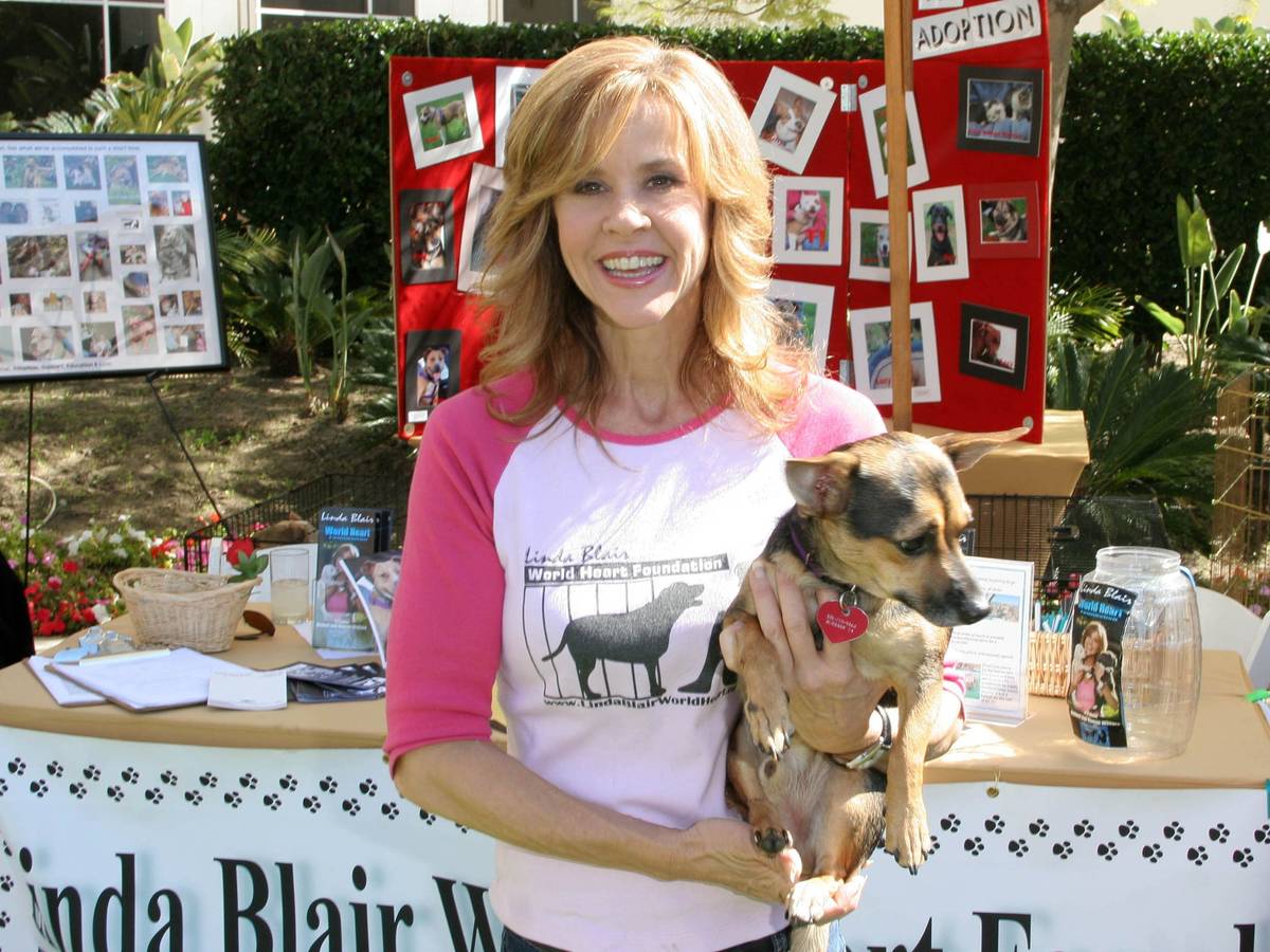 Linda Blair posiert mit einem Welpen.