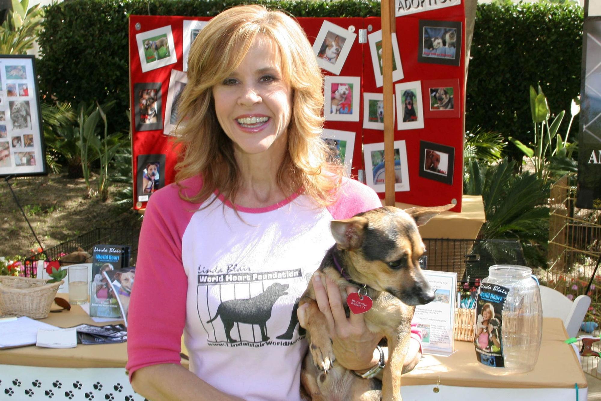 Linda Blair posiert mit einem Welpen.
