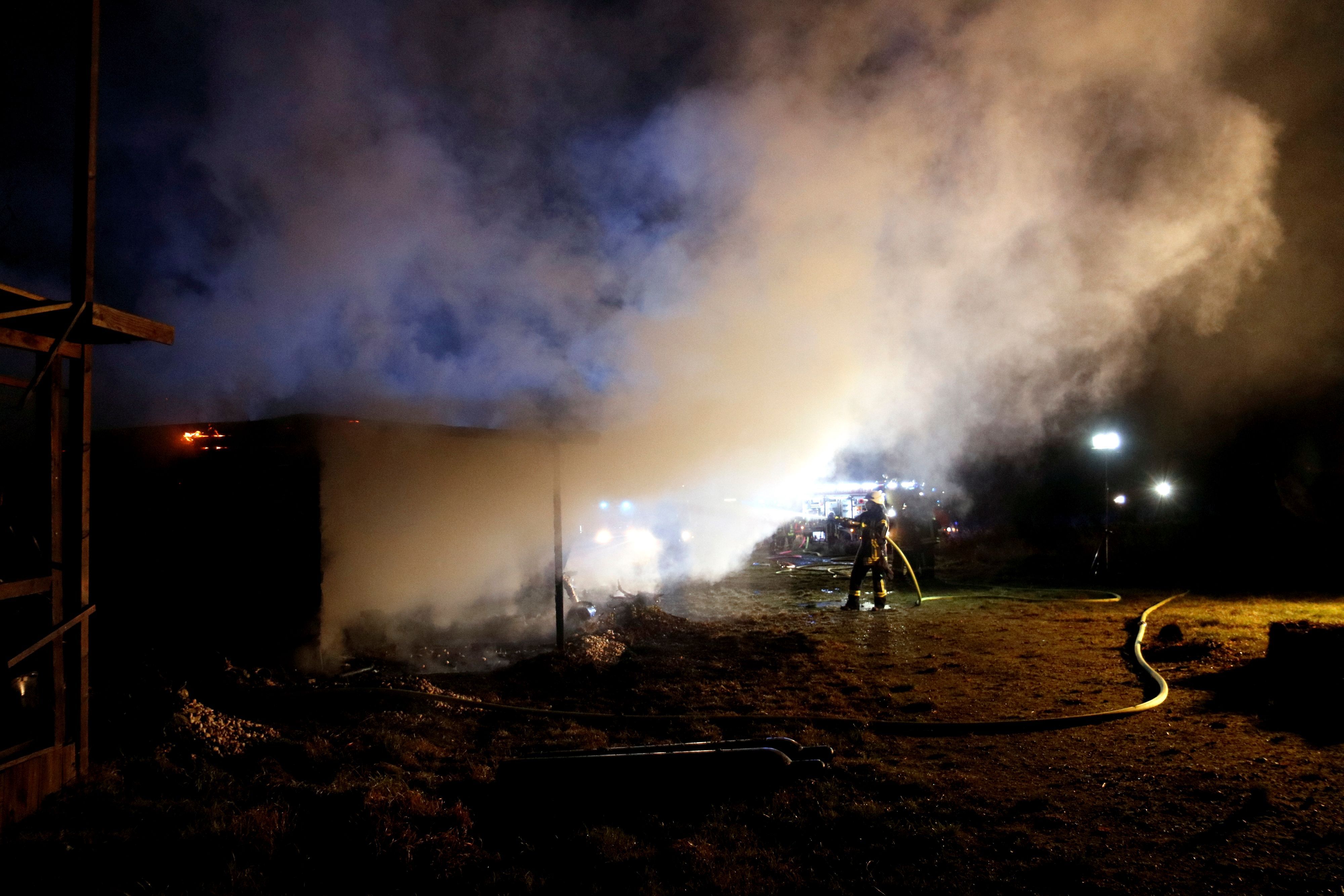 Feuerwehrleute löschen in der Nacht.