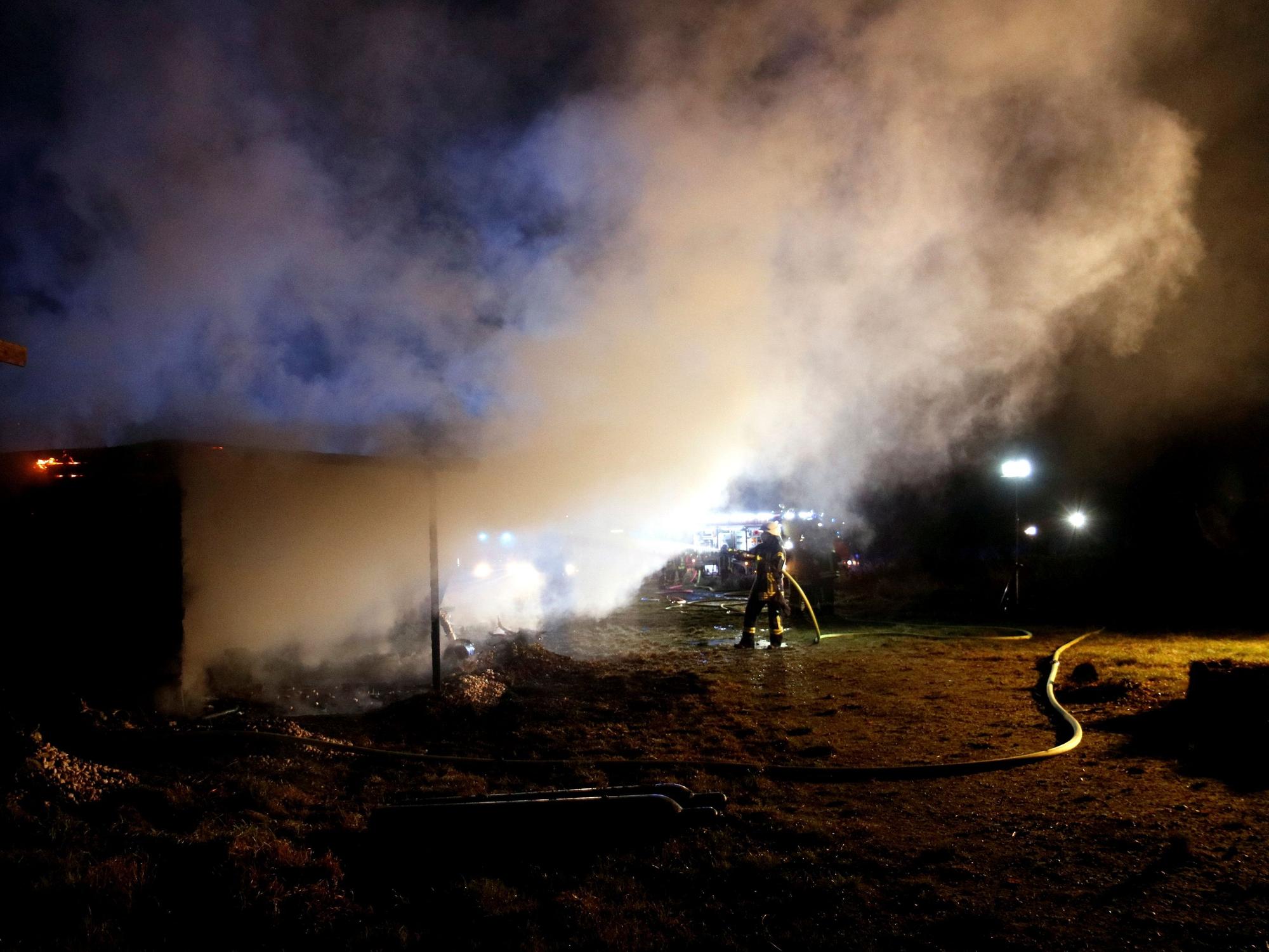 Feuerwehrleute löschen in der Nacht.
