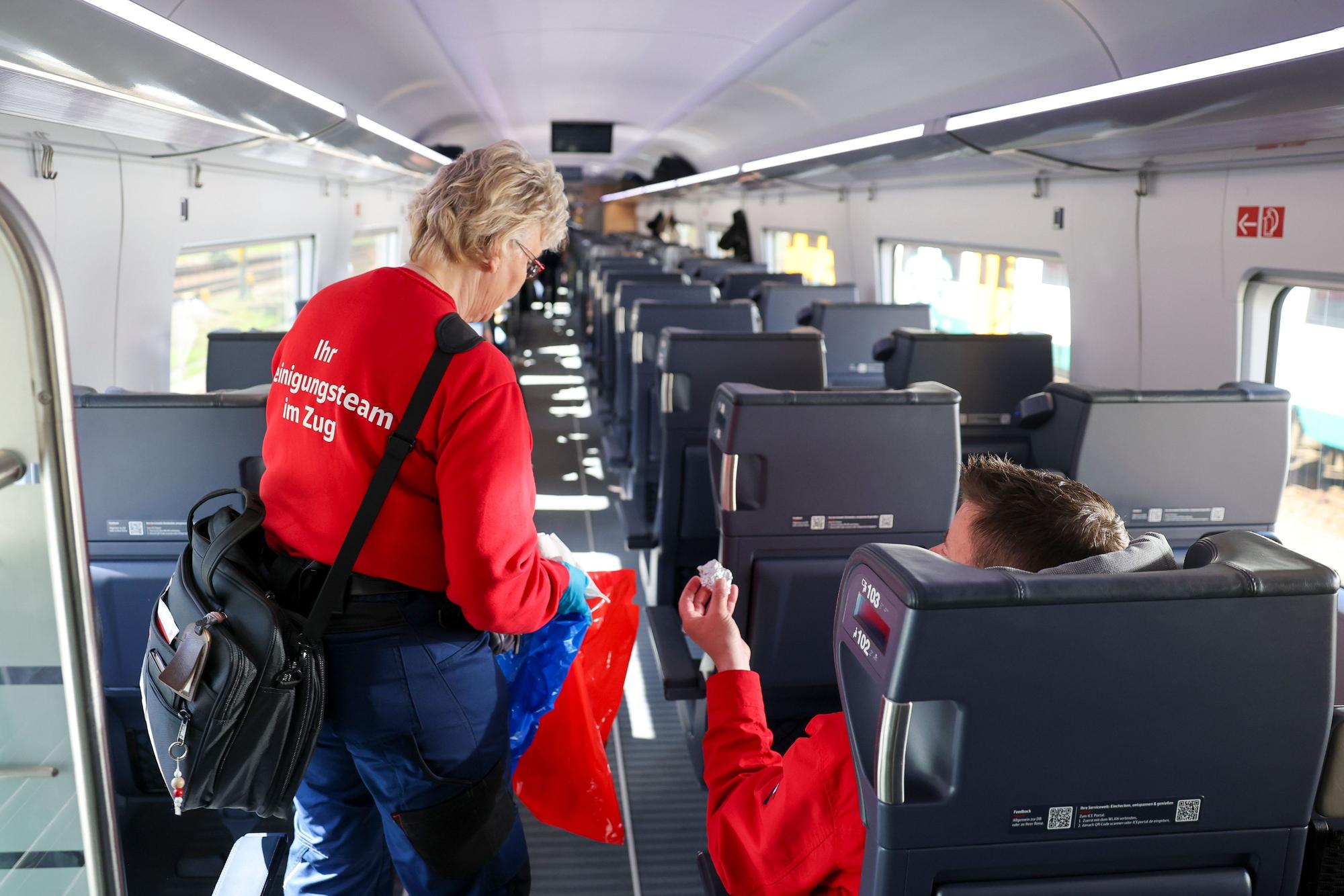 Das Symbolfoto zeigt eine sogenannte „Unterwegsreinigerin“, die den Abfall von Passagieren in einem Zug mitnimmt.