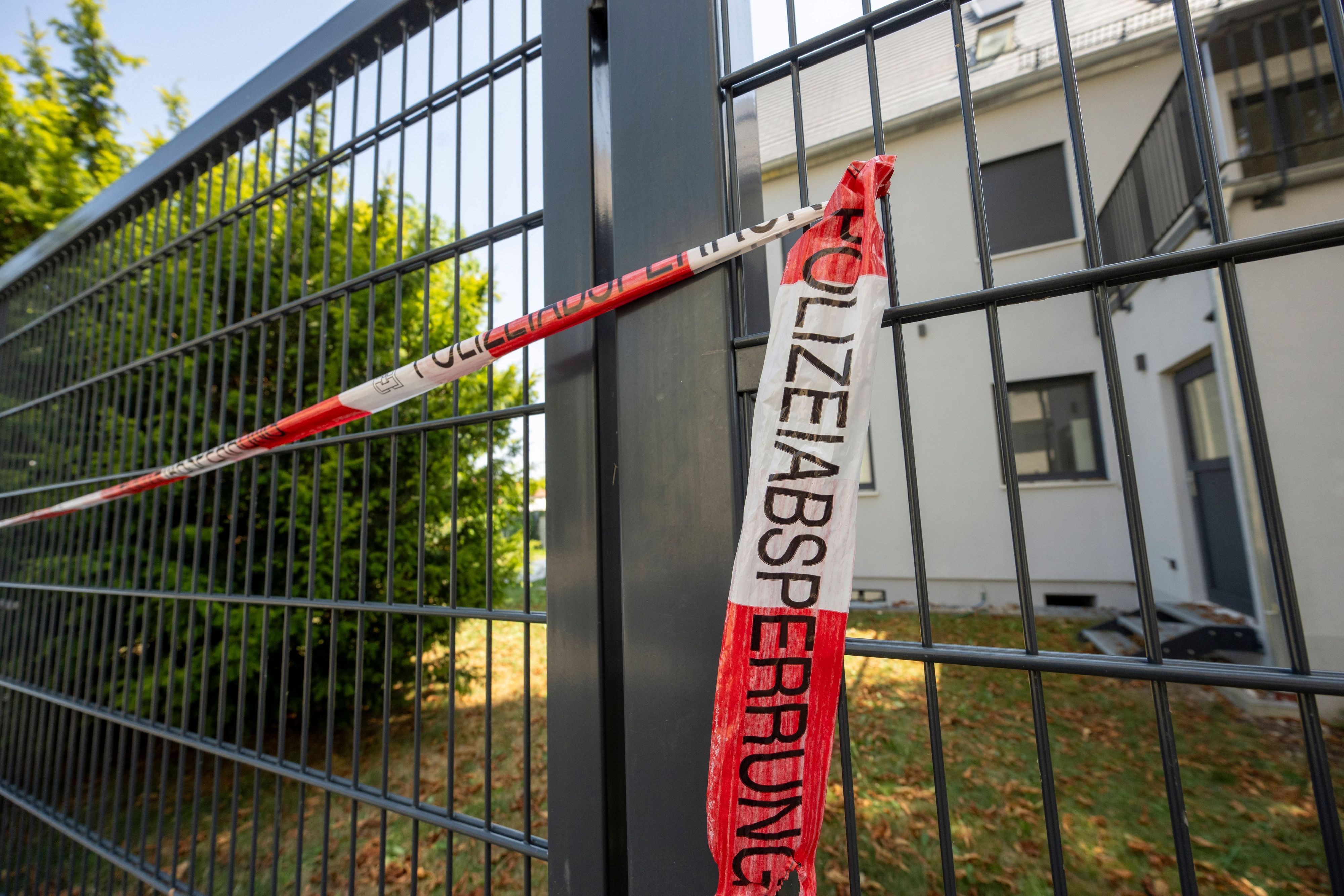 04.08.2026, Bayern, Augsburg: Vor einem Haus hat die Polizei eine Absperrung angebracht. Im Rahmen eines Polizeieinsatzes wurden am Montag dort zwei Leichen gefunden. Ein 29 Jahre alter Mann wurde festgenommen. Foto: Stefan Puchner/dpa +++ dpa-Bildfunk +++